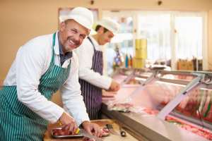 Fleischer beim /ubereiten von Fleisch