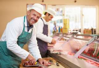 Fleischer beim /ubereiten von Fleisch