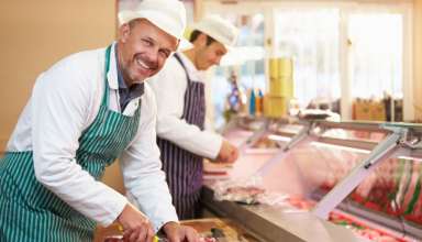 Fleischer beim /ubereiten von Fleisch